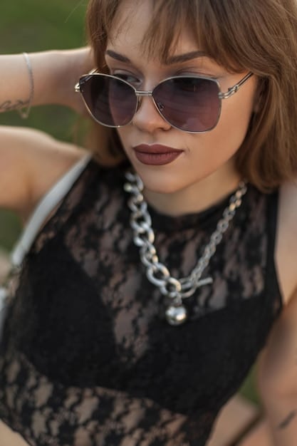 A close-up shot of Selena Gomez wearing a pair of oversized sunglasses and delicate gold jewelry.