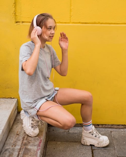 Hailey Bieber wearing a casual outfit with denim shorts, an oversized sweatshirt, and sneakers.