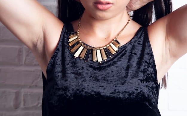 Close-up of a celebrity's outfit, focusing on the accessories. She's wearing a chunky gold necklace, oversized sunglasses, and carrying a designer handbag with a distinctive pattern. The background is blurred.