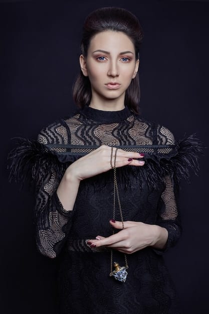 A close-up shot of a celebrity wearing a large, ornate statement necklace over a simple black dress, highlighting the necklace's intricate details and how it enhances the overall look.