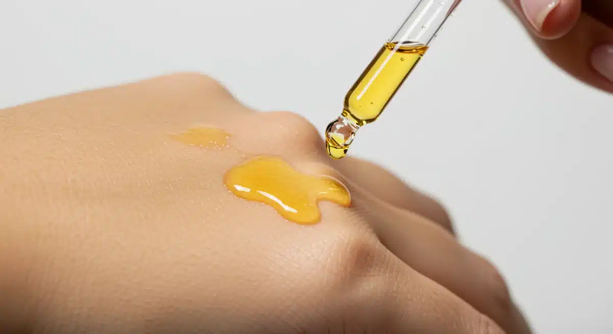 Golden serum being applied to skin, symbolizing potent active skincare ingredients